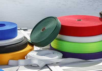 Different types of webbing straps with buckles and accessories displayed on a flat surface